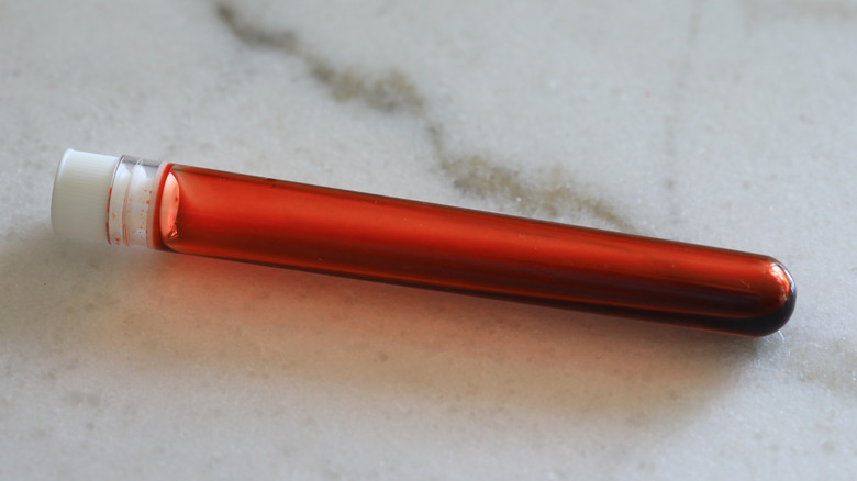 A vial of blood lays on a countertop