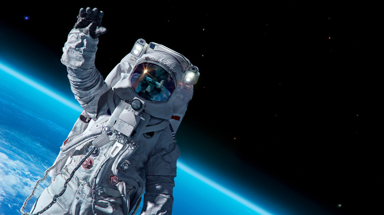 astronaut waving to camera on spacewalk