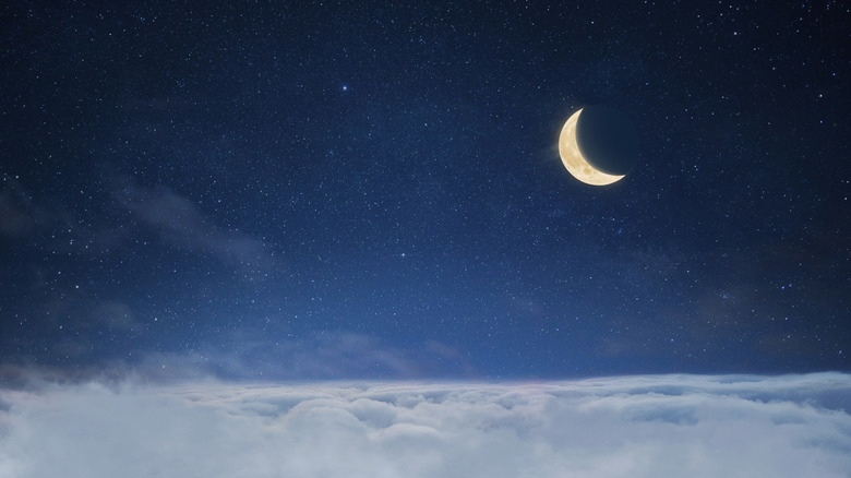 Clouds in a starry sky with a crescent moon