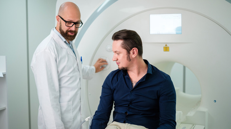 Man with a doctor in front of an MRI machine