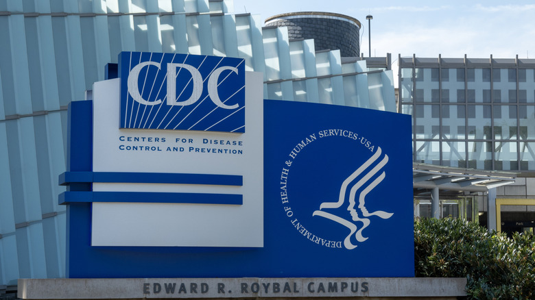 CDC sign in blue in front of campus building made of light blue columns