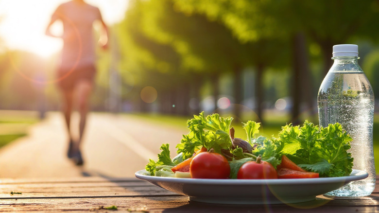 Plate of vegetables and bottle of water with a man running in background