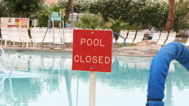 Public pool with closed sign in front of it