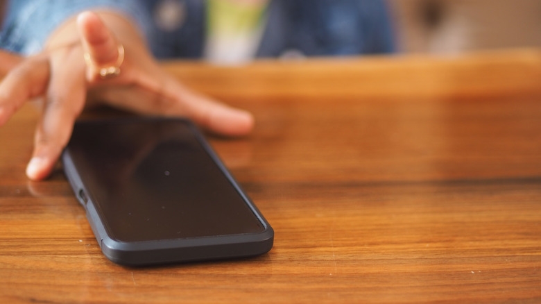 Hand laying smartphone down on a table