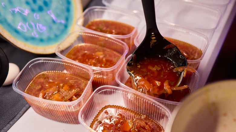 Soup being portioned into small plastic containers