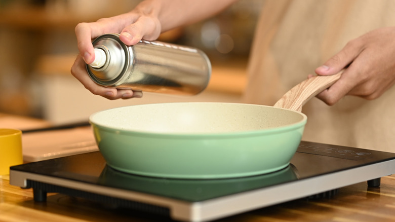 Spraying cooking oil into a frying pan