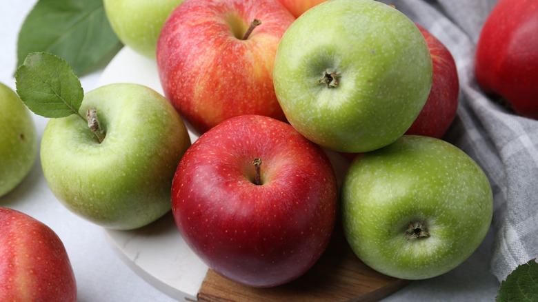 Fresh ripe apples on light grey table