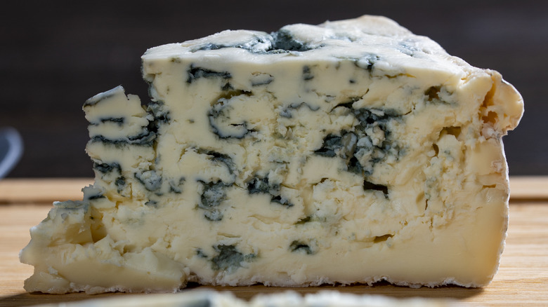 Wedge of blue cheese on a cutting board