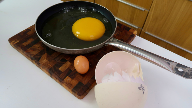 Ostrich egg cracked into a frying pan