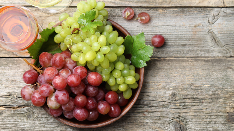 Red and green grapes together in a wooden bowl