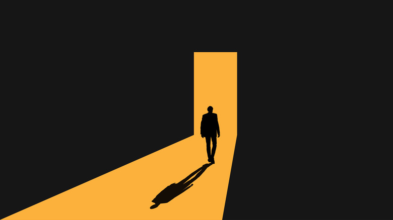 Vector art of a person standing in the light of an open doorway.