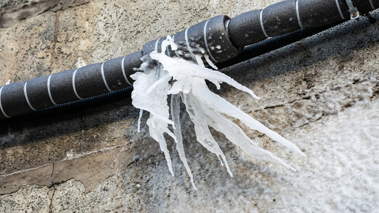 frozen water hanging from a burst outdoor pipe