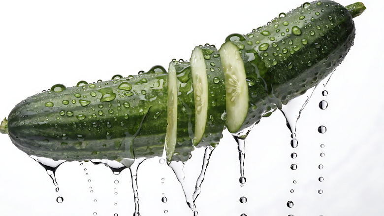 Water dripping from a cucumber sliced into pieces in the center