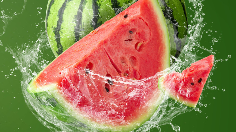 Water swirling around cut watermelon