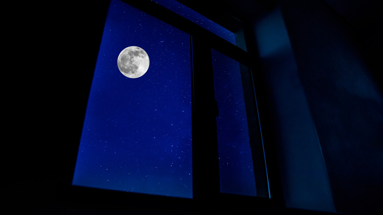 Full moon shining through a window