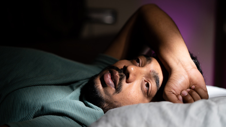 Man experiencing insomnia while in bed