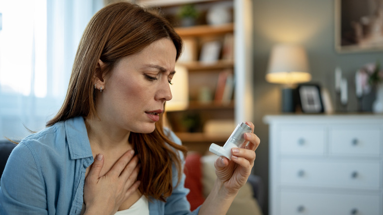 Woman with breathing difficulties holding an inhaler
