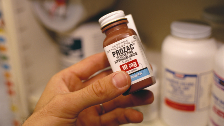 Hand holding a bottle of Prozac
