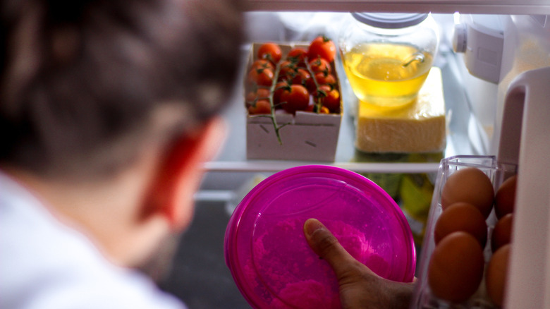 Person standing in front of an open fridge