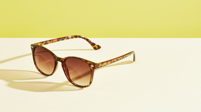 sunglasses sit on a table against a yellow background