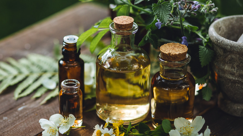 Assortment of essential oils on a table with flowers