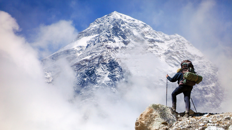 Tourist pausing to take in the view of Mount Everest from Kala Patthar while on the way to base camp