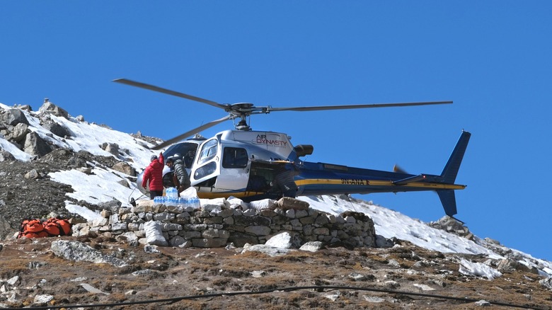 People unloading supplies from a helicopter landing at a Mount Everest base camp in Nepal