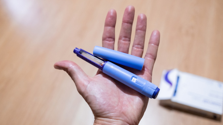 Hand holding a GLP-1 pen