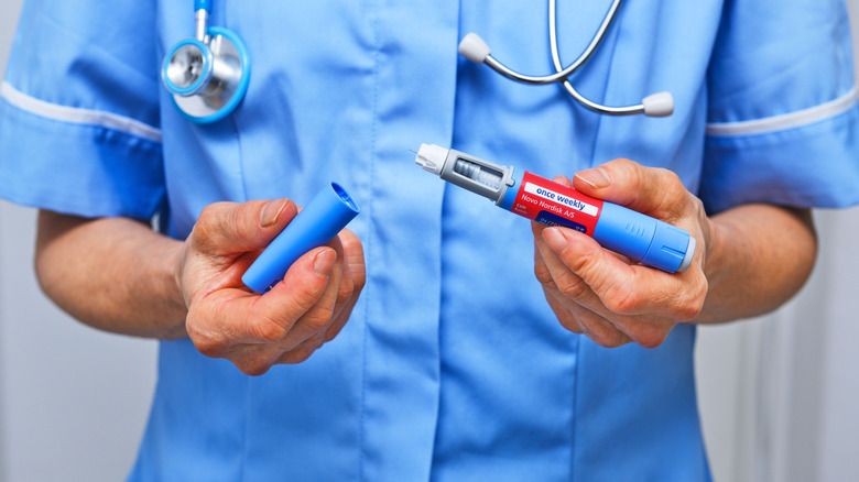A healthcare professional holding a GLP-1 pen