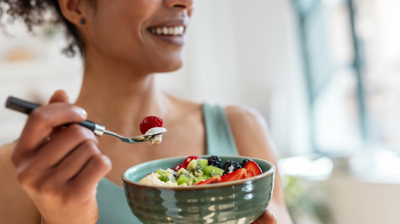 Close-up of a woman eating a fruit bowl