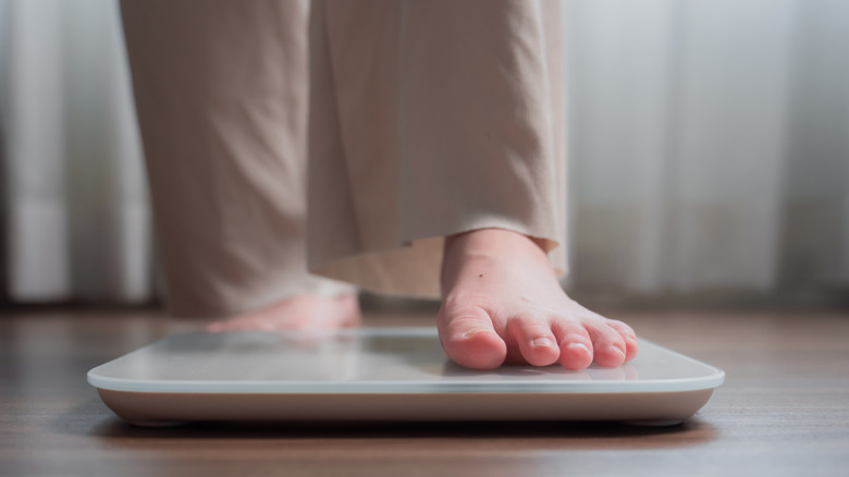 A person's feet stepping on a scale