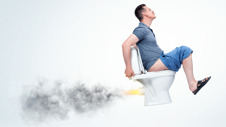 Man on toilet that's taking off into the air in a representation of explosive diarrhea
