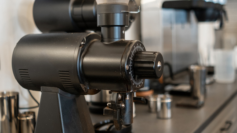 A professional coffee grinder on a counter in a coffee shop.