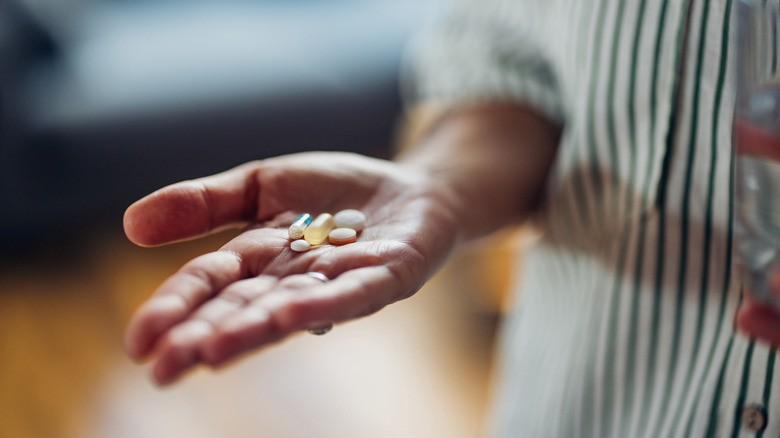 Closeup of a hand holding several different pills
