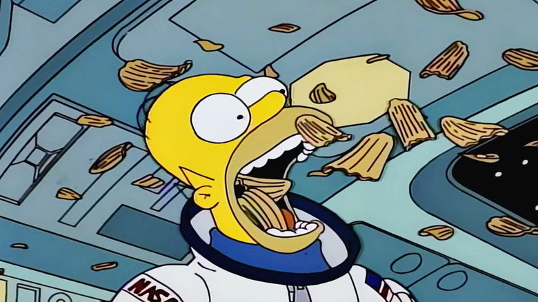 Homer Simpson eats chips out of the air while in a spacecraft in The Simsons