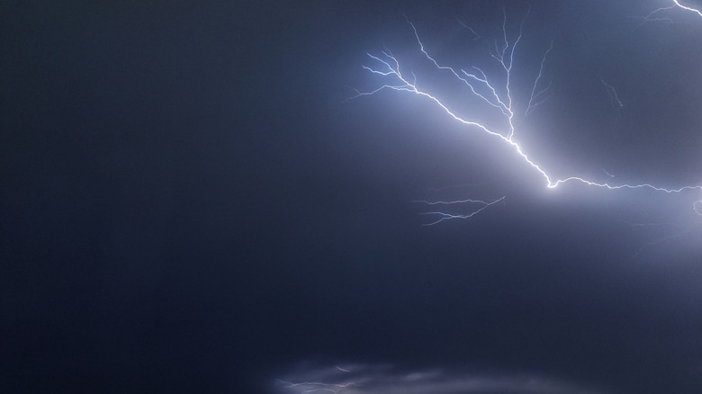 Lightning strike flashes through clouds