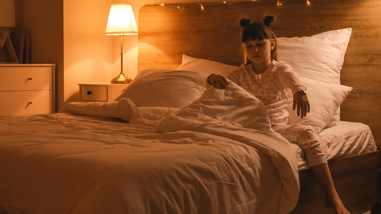 Young girl sleepwalking from her bed