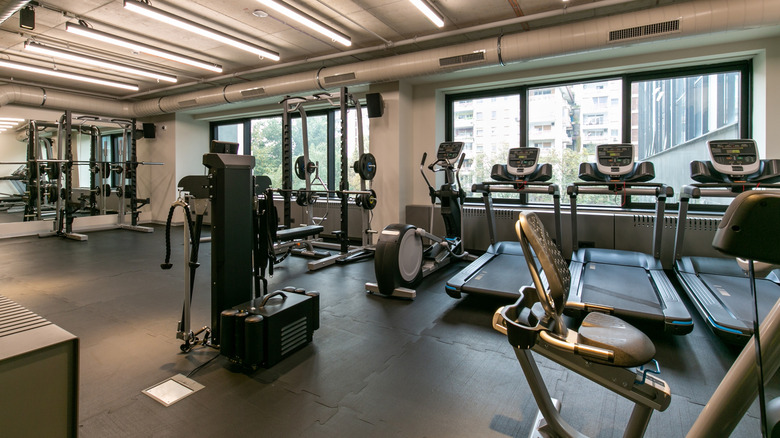 Interior of a gym with treadmills, weights, and stationary bicycles