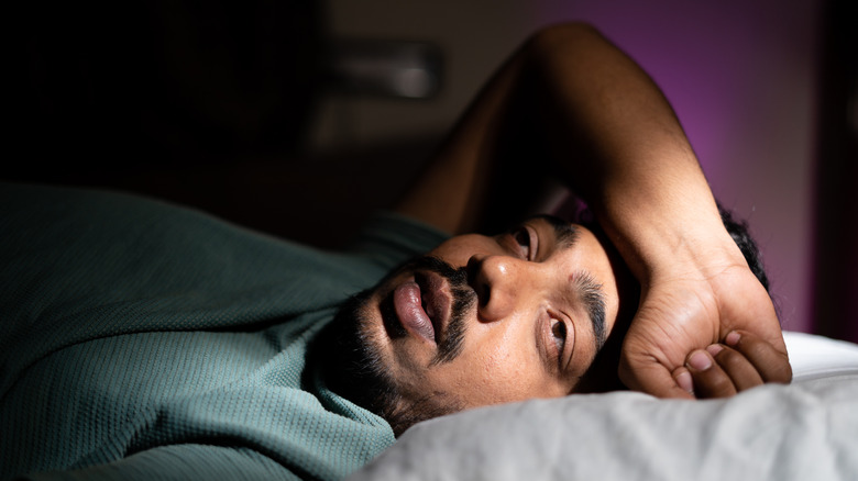 Man in bed experiencing insomnia