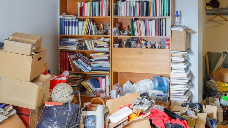 Hoarder's living room filled with books, boxes, and other items