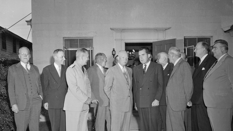 Members of the newly-formed Central Intelligence Agency stand around President Eisenhower, with Allen Dulles looking into the camera on the far left of the image.
