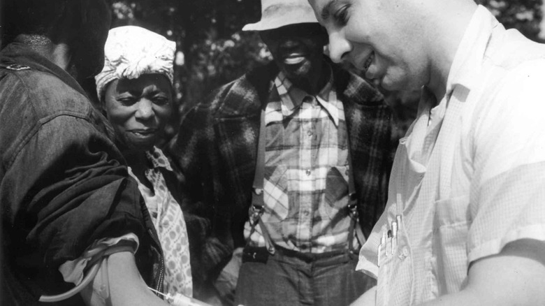 A man is being injected as part of the Tuskegee syphilis study.