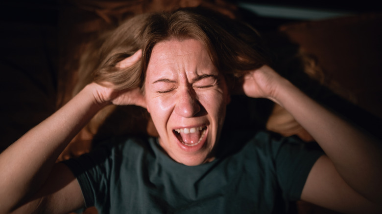 A woman screams while laying in bed
