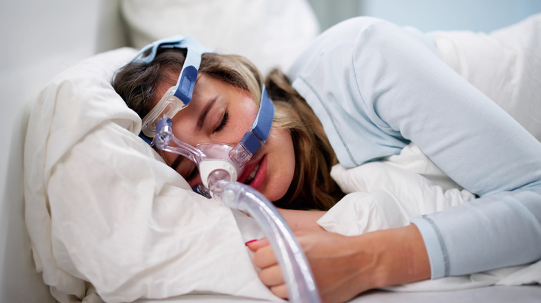 Woman sleeping wearing a sleep apnea mask