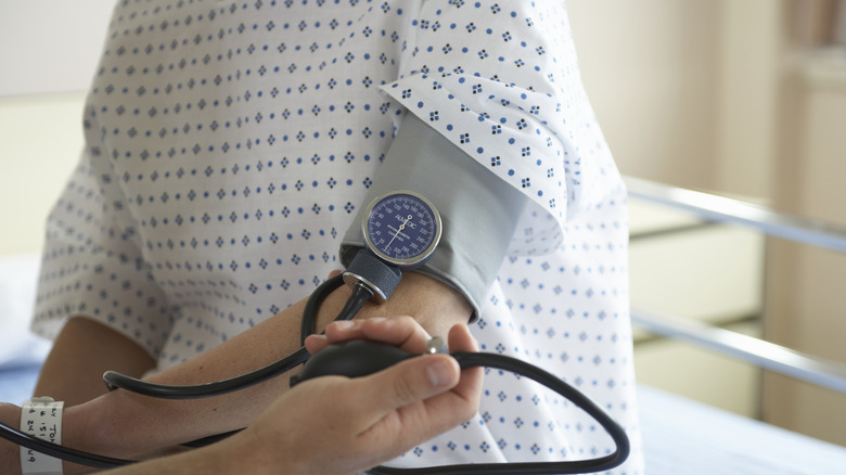A patient having their blood pressure measured in a hospital room