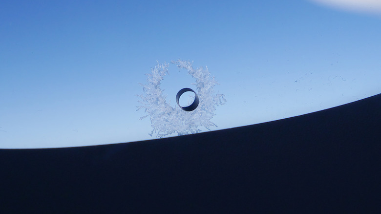 Frost can be seen around the bleed hole of a plane window