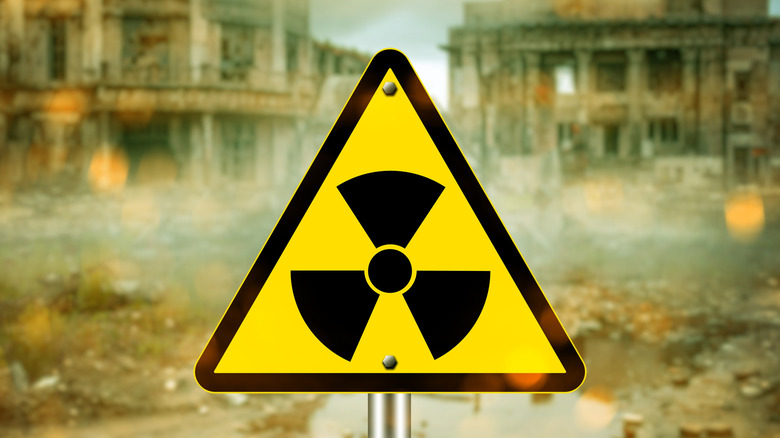 A radiation warning sign is seen amid a crumbling wasteland
