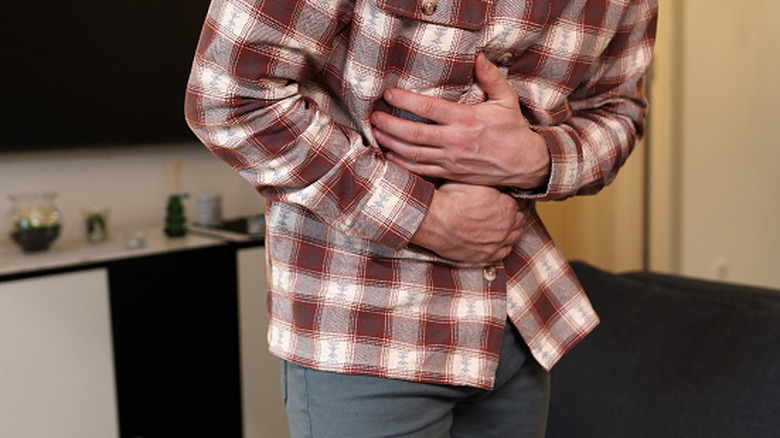 Man holding hands over abdominal area in pain