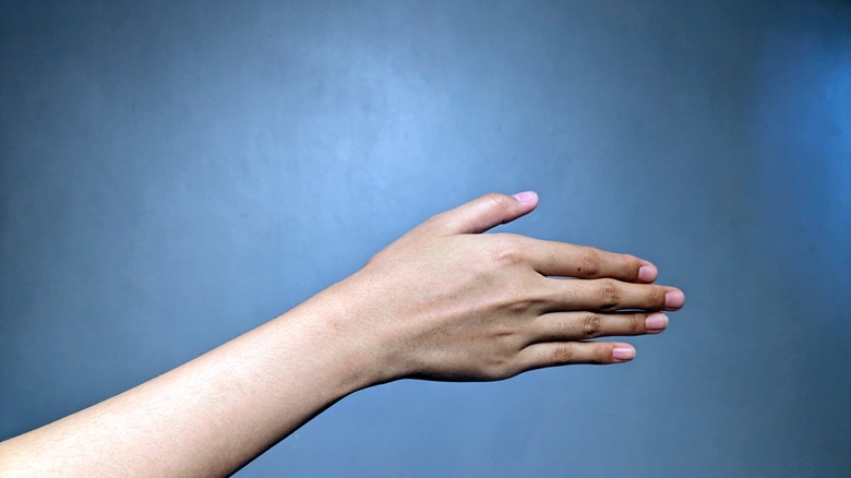 Close up of person's forearm against blue background
