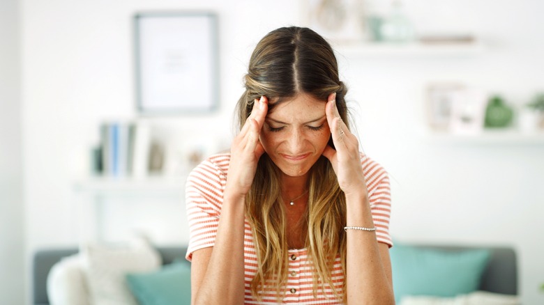 Woman holding her head in pain